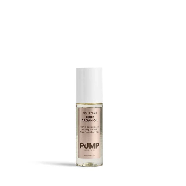Bottle of pure argan oil with pump for dry hair on a white background