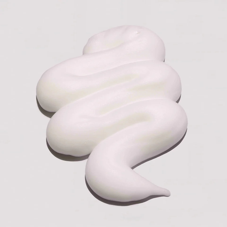 White, creamy swirl on a light gray background milk_shake Lifestyling Volumizing Foam