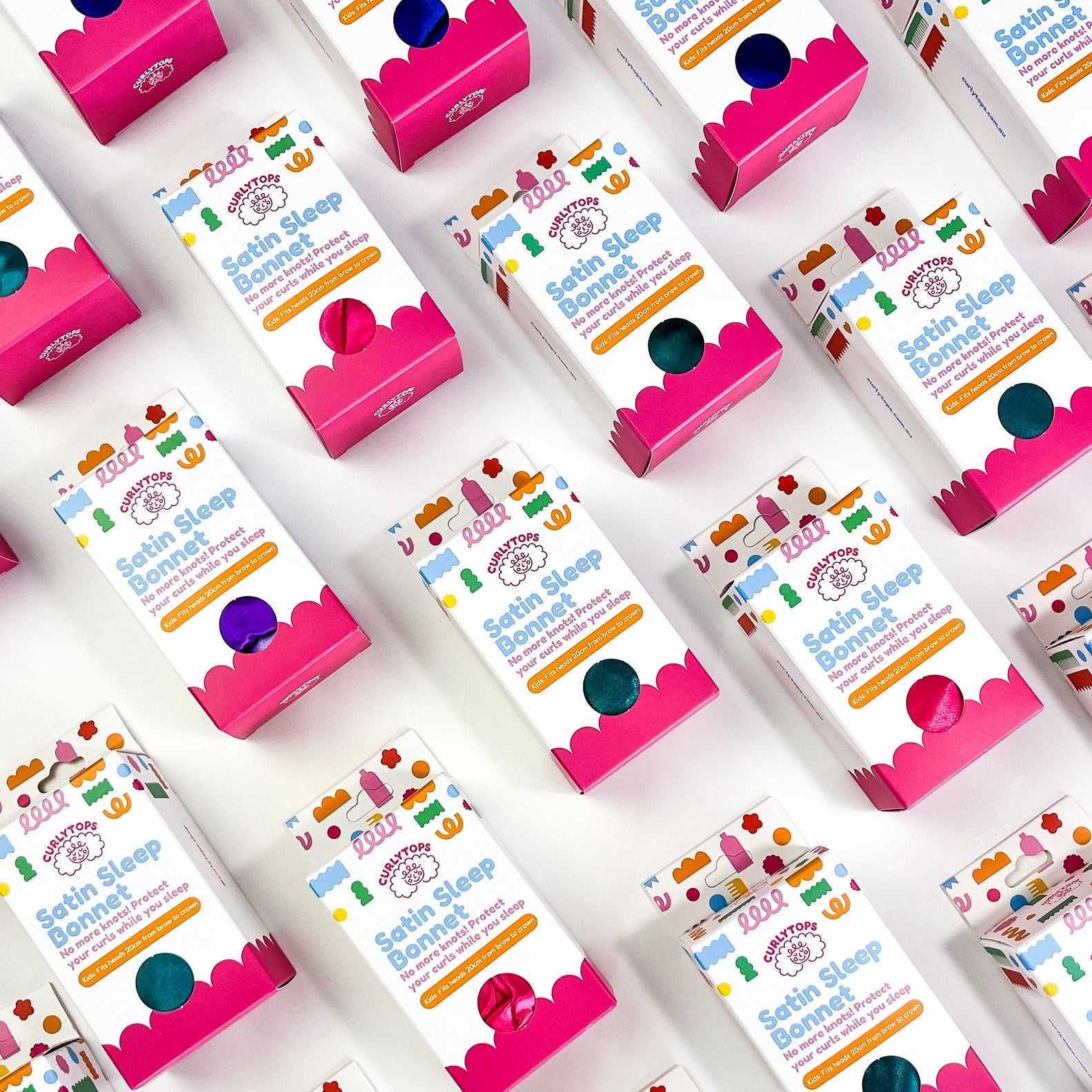 Multiple boxes of Satin Sleep Bonnets on a white background