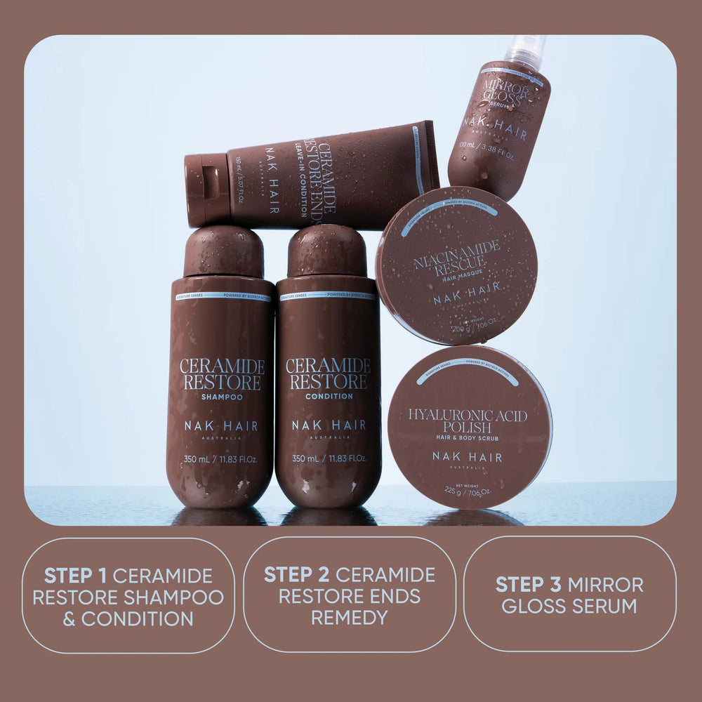 Nak Hair 'Your Signature Ritual' hair care set featuring three brown bottles, a brown tube, and three round containers on a light blue reflective surface, set against a brown background with descriptive text boxes.
